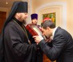 Приложился. Губернатор Юрий Чмырь целует священный образ в руках епископа Евлогия